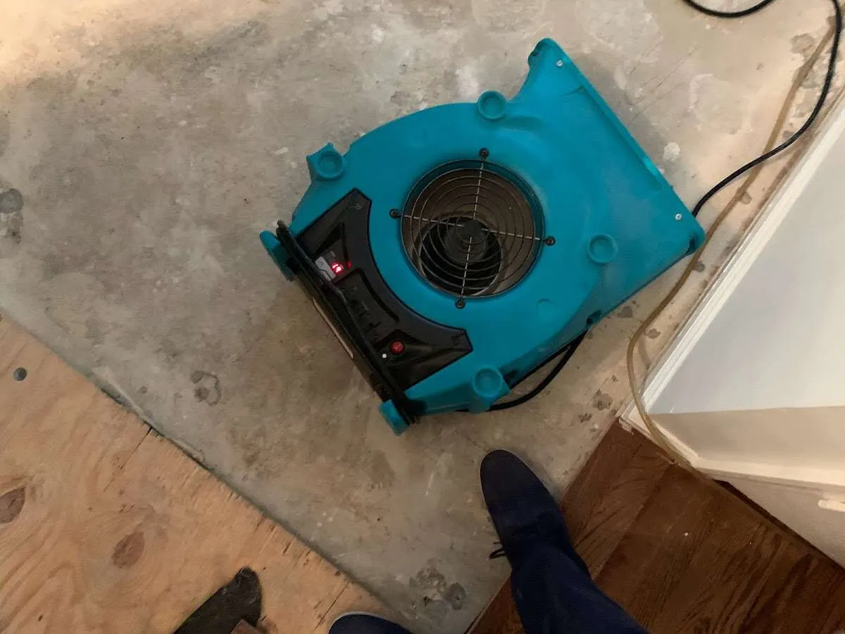 Air mover drying subfloor during Commercial Water Damage Restoration in Oelwein